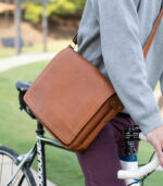 leather messenger bag being worn while riding a bike through downtown