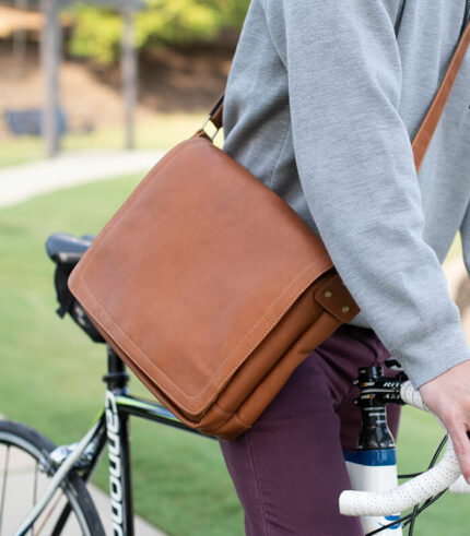 leather messenger bag being worn while riding a bike through downtown