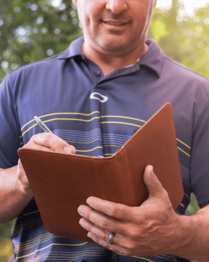 Man writing in a Nino leather journal